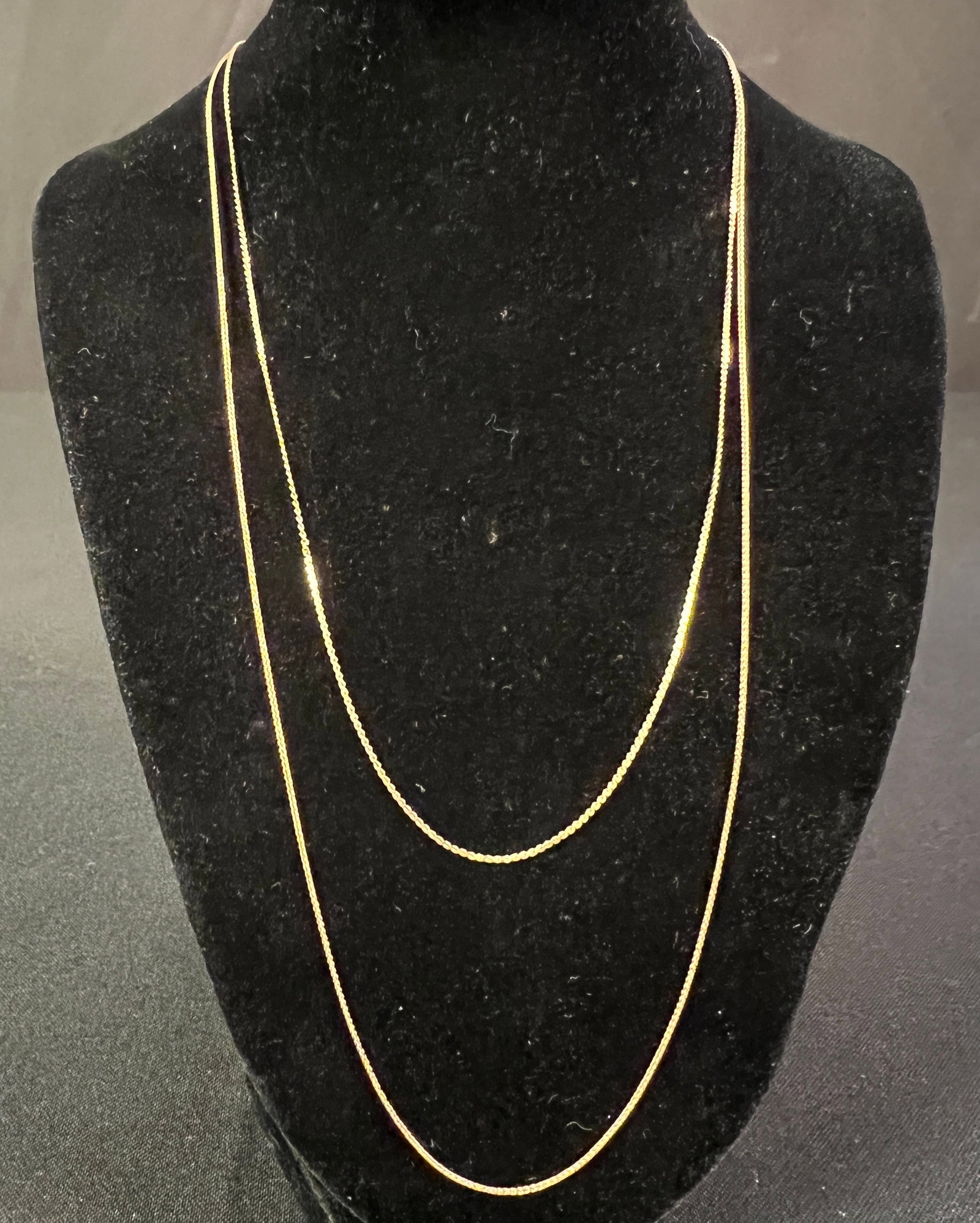 Two 14K Yellow Gold Chains: Two 14K yellow gold chains, the first is in excellent condition and measures 22" long and weighs 2.11g. The second chain has one minor kink and measures 20" long and weighs 1.81g.