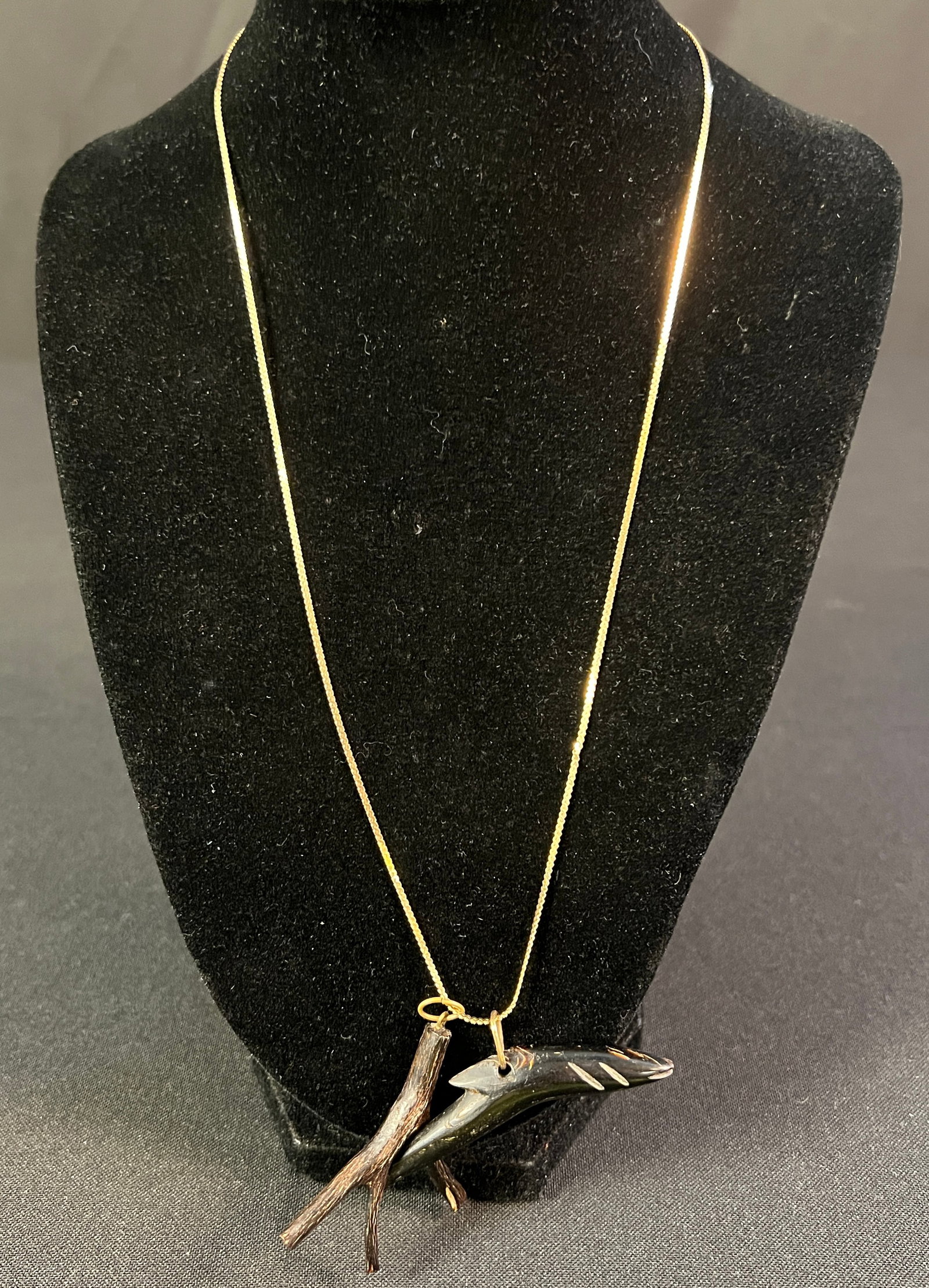 14K Gold Necklace w/ Ebonized Charms: A 14k gold chain with 2 ebonized charms. One appears to be a carved fish and the other resembles a tree branch. The chain measures 20" long and weighs 2.67grams.