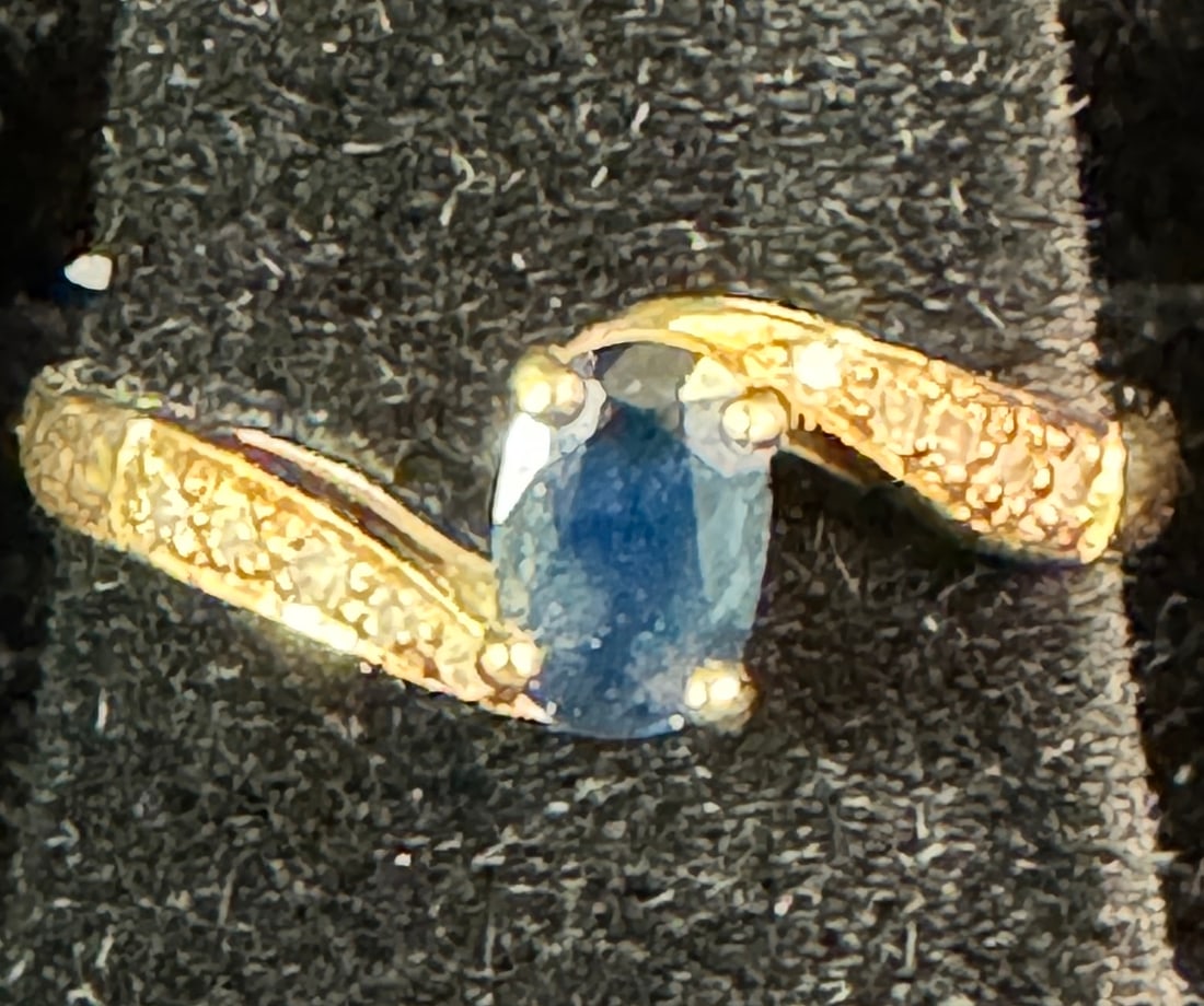 10K Saphire and Diamond Ladies Ring: A 10k sapphire and diamond ladies ring that features a central oval sapphire with pleasant deep blue coloration. It is size ~6.25 and weighs 2.08grams.