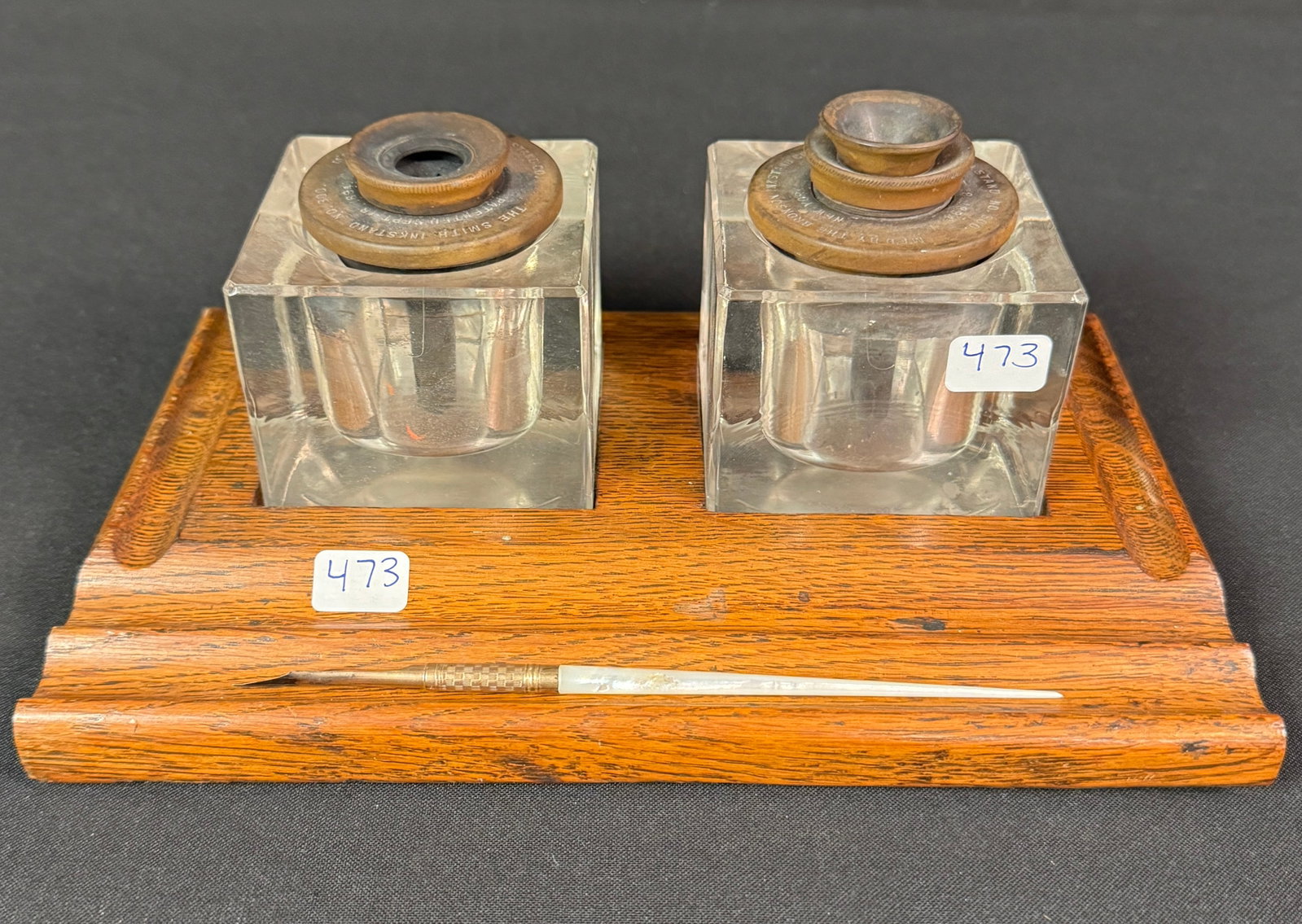 1890s Bronson Double Ink Stand w/ Ornate Victorian Pen: A 1890s Bronson double ink stand with two glass inkwells and wooden tray. Also included is a Victorian Mother of Pearl and gold filled nib pen. In very good condition.