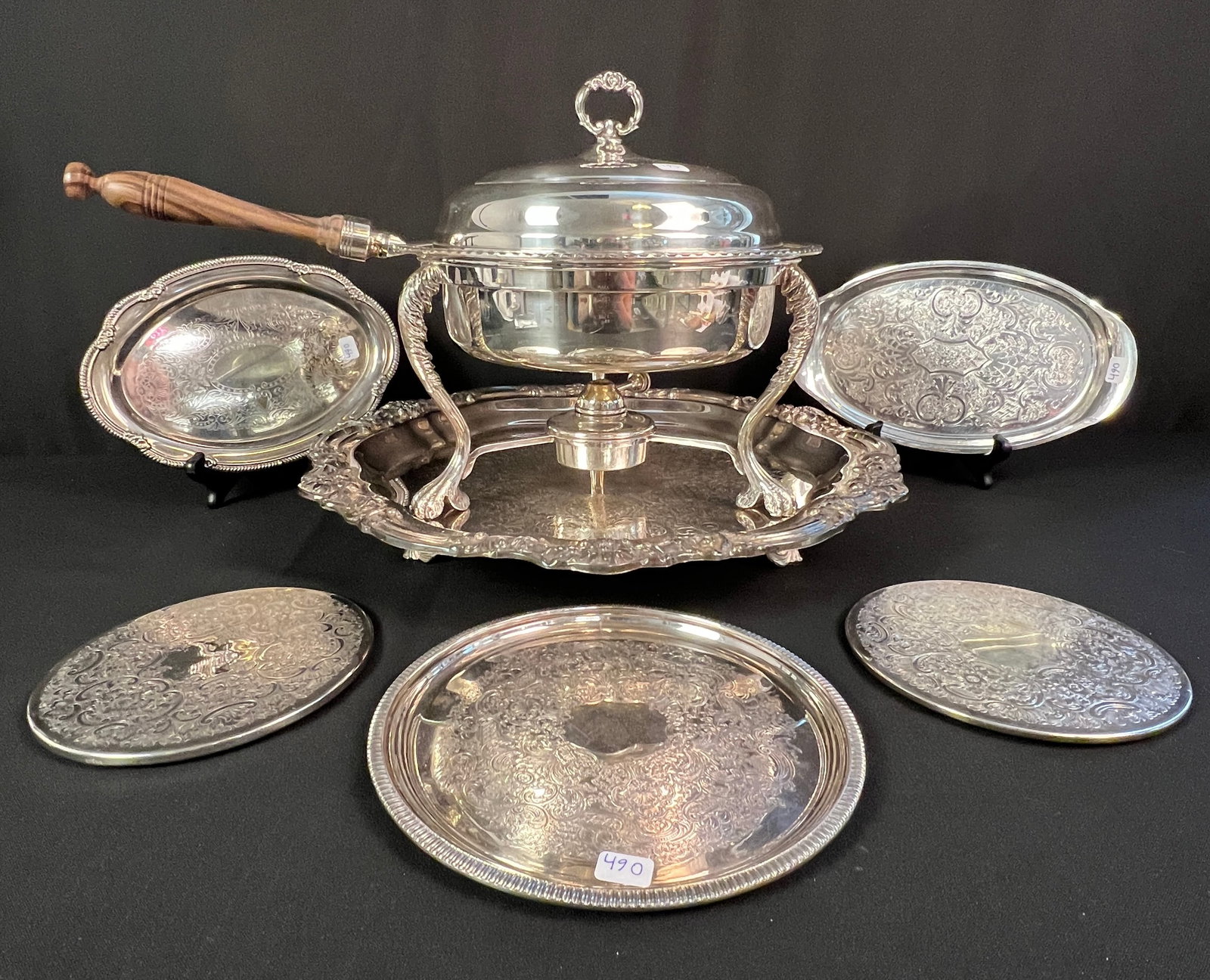 Silver Plate Chafing Dish, Heated Tray and More: A group of silver plate to include a handled chafing dish with removable burner, a large ornate serving tray with heating element, two circular trivets, and three small trays. In excellent, working
