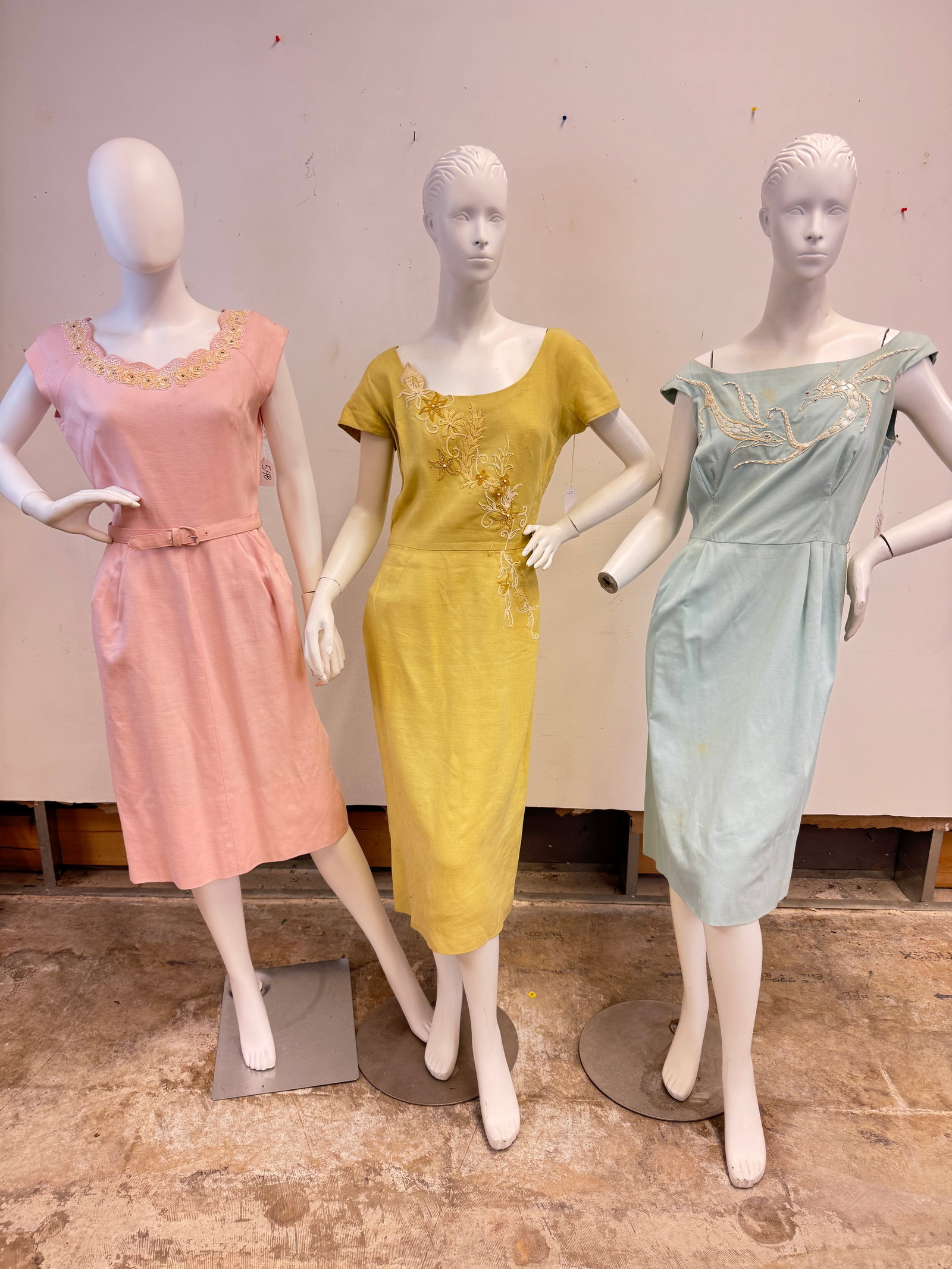 3 Vintage Ladies Dresses C1950's: Three vintage ladies dresses c.1950's to include a chartreuse linn Carlyle cap sleeve fitted dress with floral embroidery, a pink linen sleeveless dress with a scoop neck, hip pockets and floral neckl
