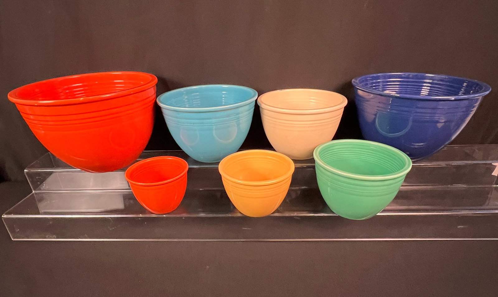 Antique Fiesta Bowls: A complete set of seven antique Fiesta nesting bowls. From largest to smallest the colors are orange, blue, turquoise, cream, green, yellow and orange. All in excellent condition, the biggest measures