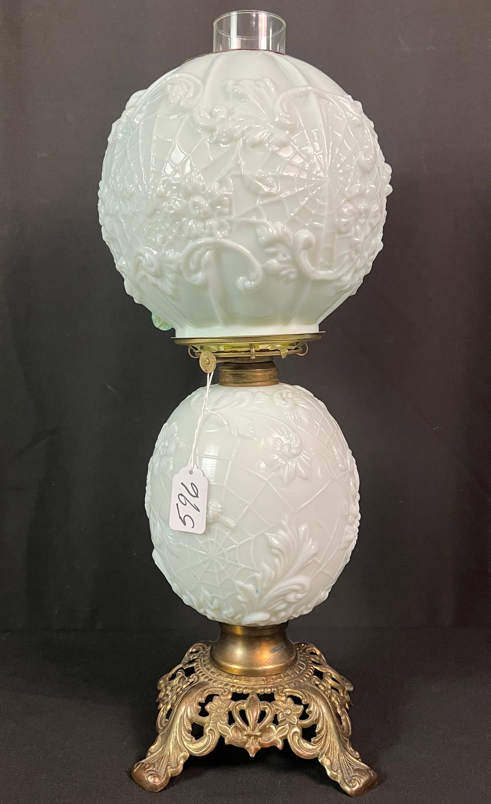 Floral Molded Oil Lamp: A floral and spider web molded two part matching oil lamp, in original antique condition. It measures 20" tall.