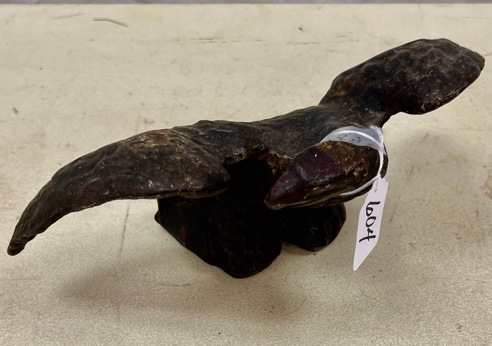 Cast Iron Eagle c.1810-1830: A 1810-1830 hand forged cast iron eagle with bent head and spread wings. In good condition, it measures 5" tall X 10" across.