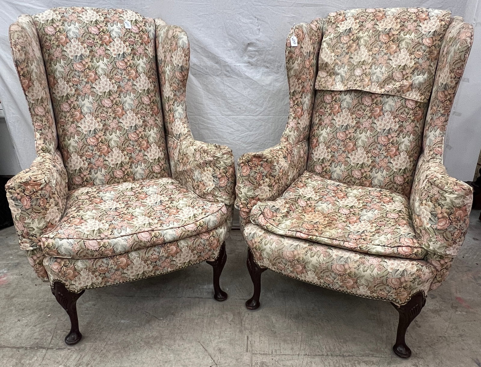 Pair of Attributed to Kittenger Wing Chairs: A pair of Kittinger-style 1920s/30s wing chairs with claw feet and carved knees, elaborate rose print w/ brass tacking and down filled. These Kittinger-style wingchairs are in excellent condition with