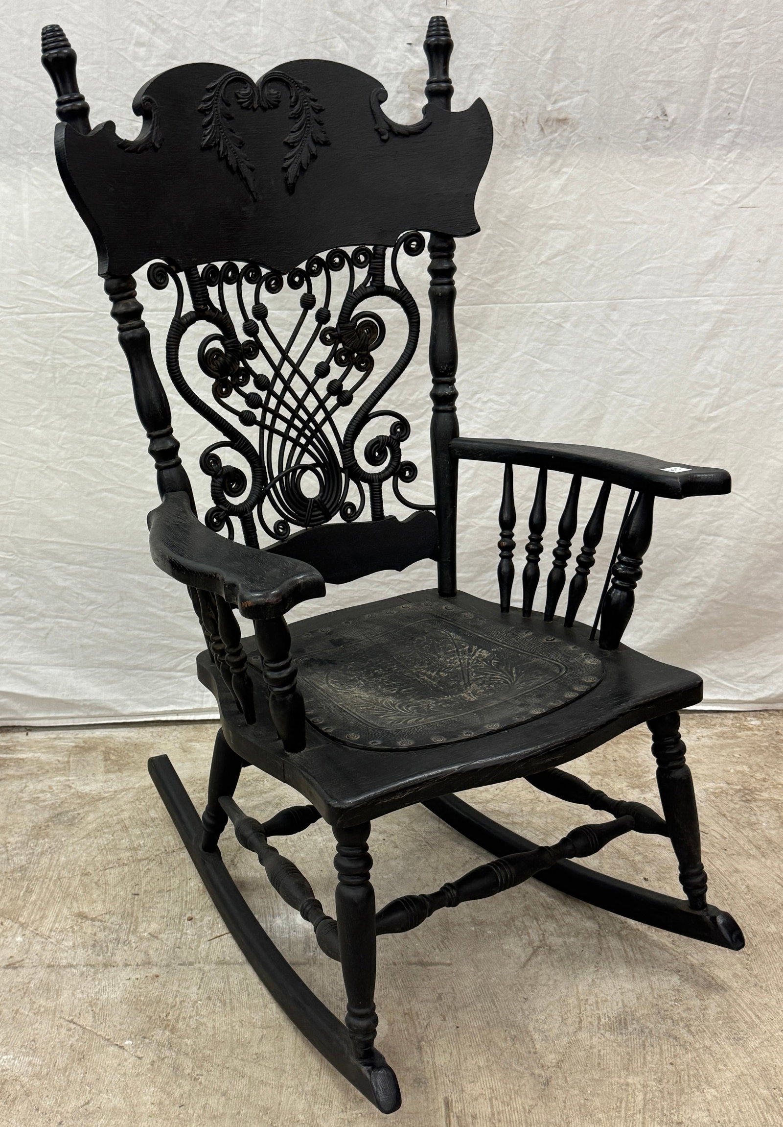 Victorian Wicker and Spindle Rocking Chair: A Victorian wicker and oak rocking chair c. 1880's which features a carved backrest, applied decorative seat, and turned spindles in very good condition.
