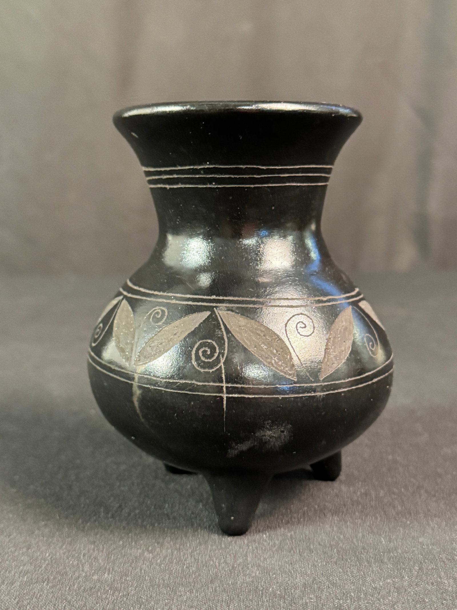 Black on Black Southwest Indian Vase: Black on Black Southwest Indian vase, floral decorated, and footed. It measures 5"h x 5".