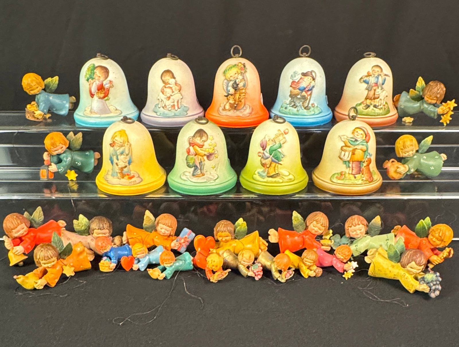 Large VIntage Group of ANRI Italian Hand Carved Christmas Angel Ornaments and Rouge Musical Bells: A large vintage group of ANRI Italian hand carved ornaments to include 13 4" long angels Christmas Ornaments carrying hearts, stars, fruit, candles, and lanterns, 8 2,25" long angel ornaments, and 9 R