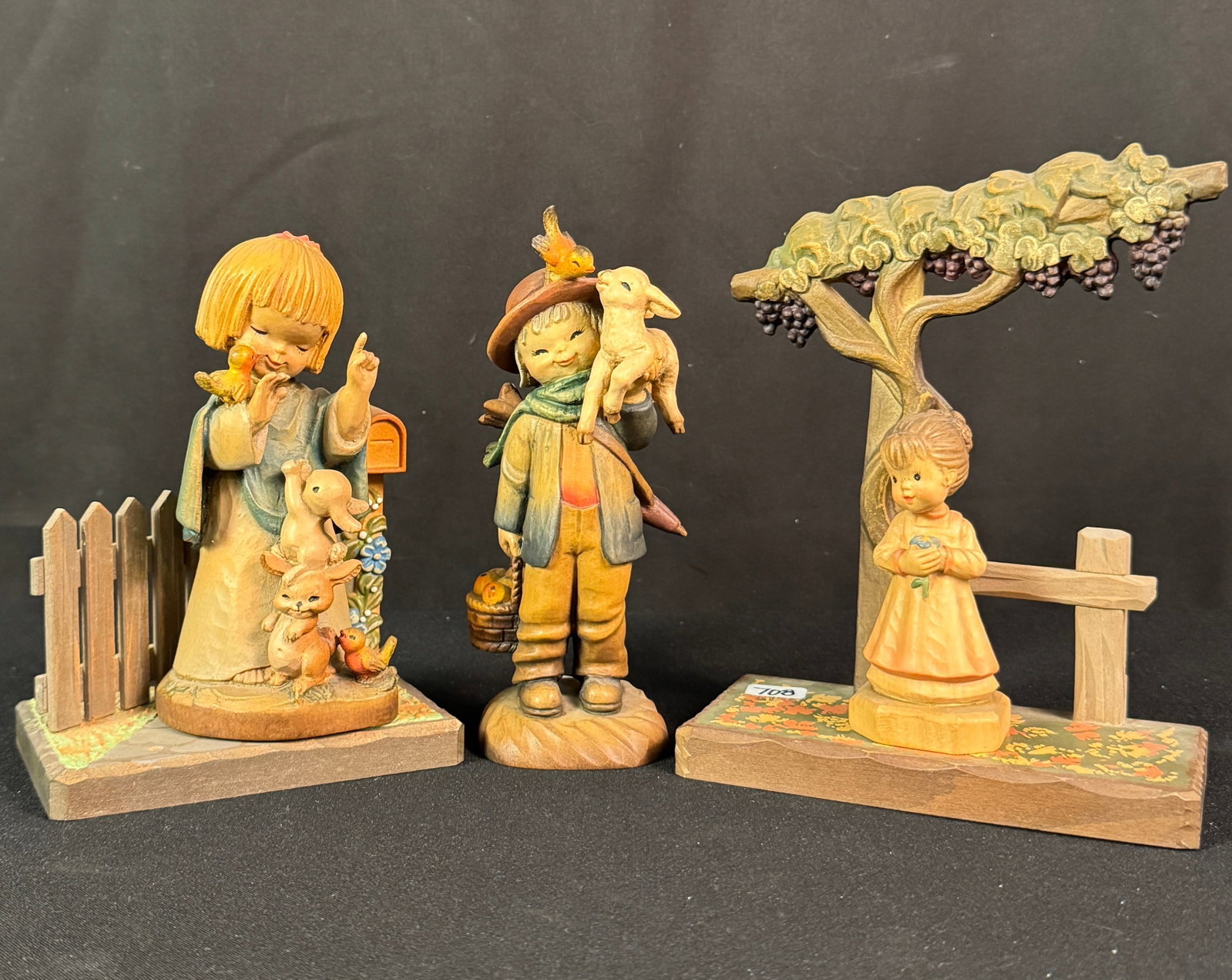Vintage ANRI Italian Hand Carved Wooden Figurines: A group of vintage ANRI Juan Ferrandiz signed hand carved Italian wooden figurines to include 6.5" Friendship, 6" tall "Talking to the Animals", ANRI CLub " 4" tall little girl with flower, a 7" tall