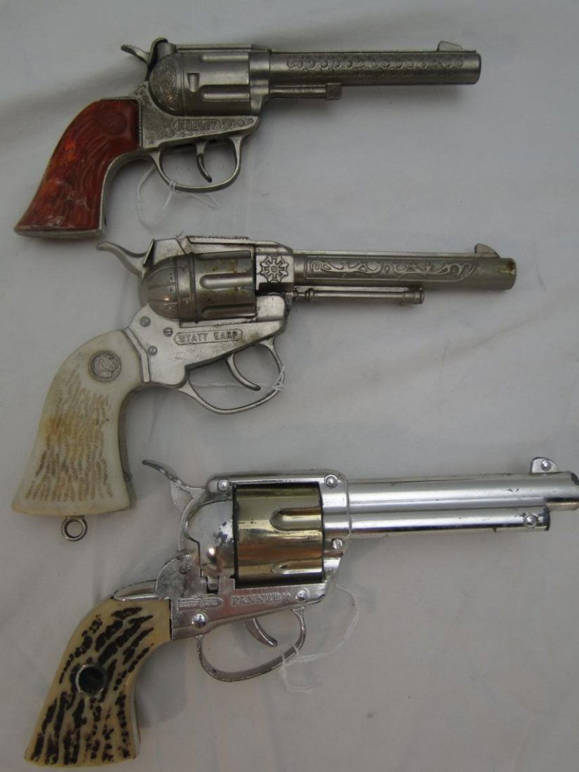 3 toy cap pistols to include "Rodeo Hubley" with orange: 3 toy cap pistols to include "Rodeo Hubley" with orange handle, "Wyatt Earp", and "Shootin' Shell Fanner" by Mattel