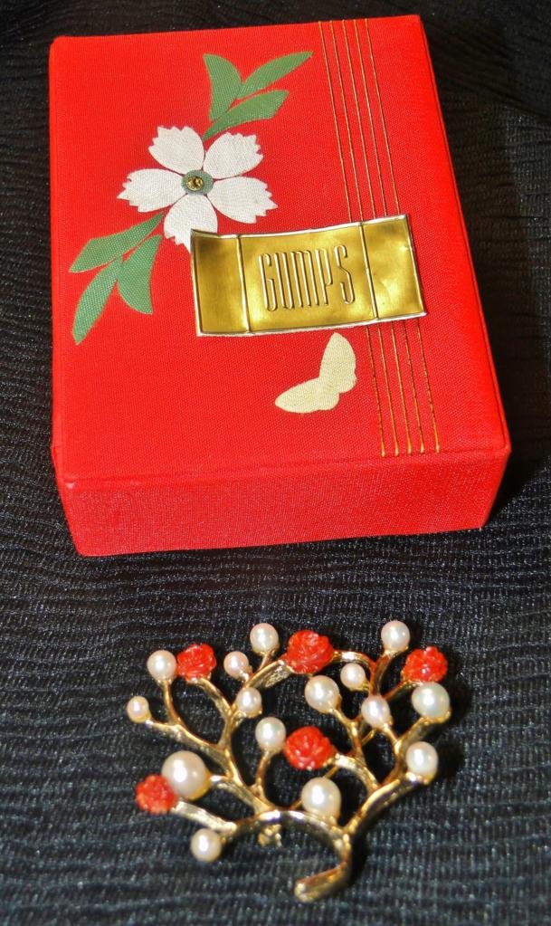 A floral carved coral and cultured pearl rolled gold: A floral carved coral and cultured pearl rolled gold broach by Gumps of San Francisco with paperwork and its original box. Measures 2.5" tall.