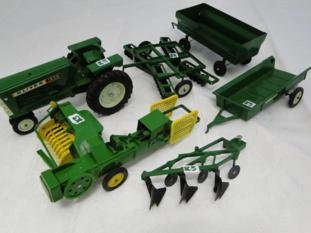 A group of Ertl farm equipment to include an older: A group of Ertl farm equipment to include an older tractor, a John Deere bailer, two trailers and two tillers in played-with condition.