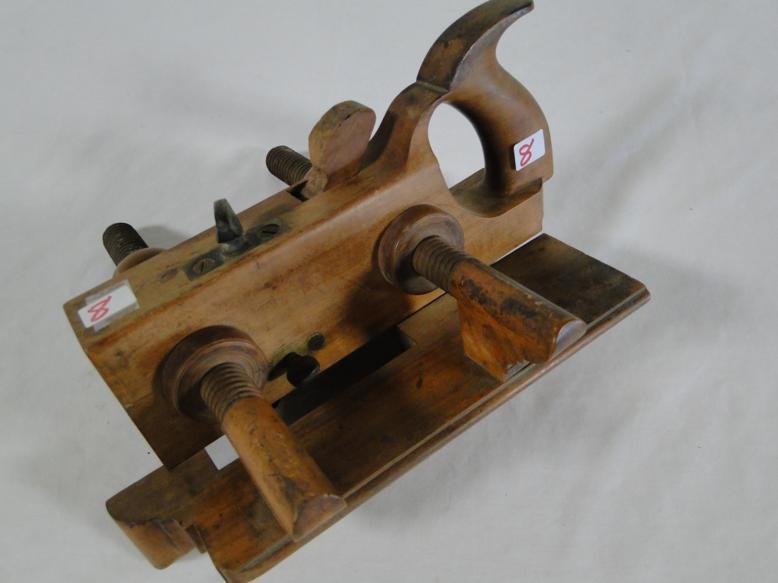 An antique wooden adjustable molding plane with handle