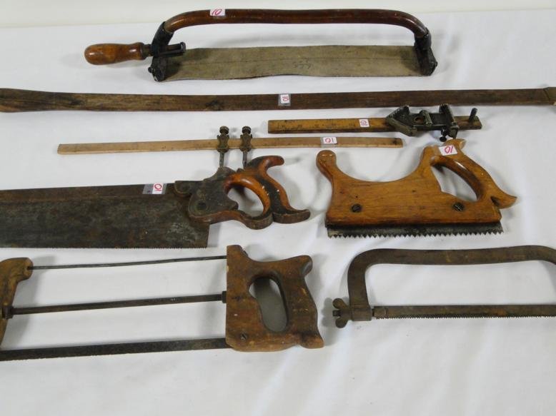 A group of antique tools to include measures, saws, and: A group of antique tools to include measures, saws, and sharpening strap.