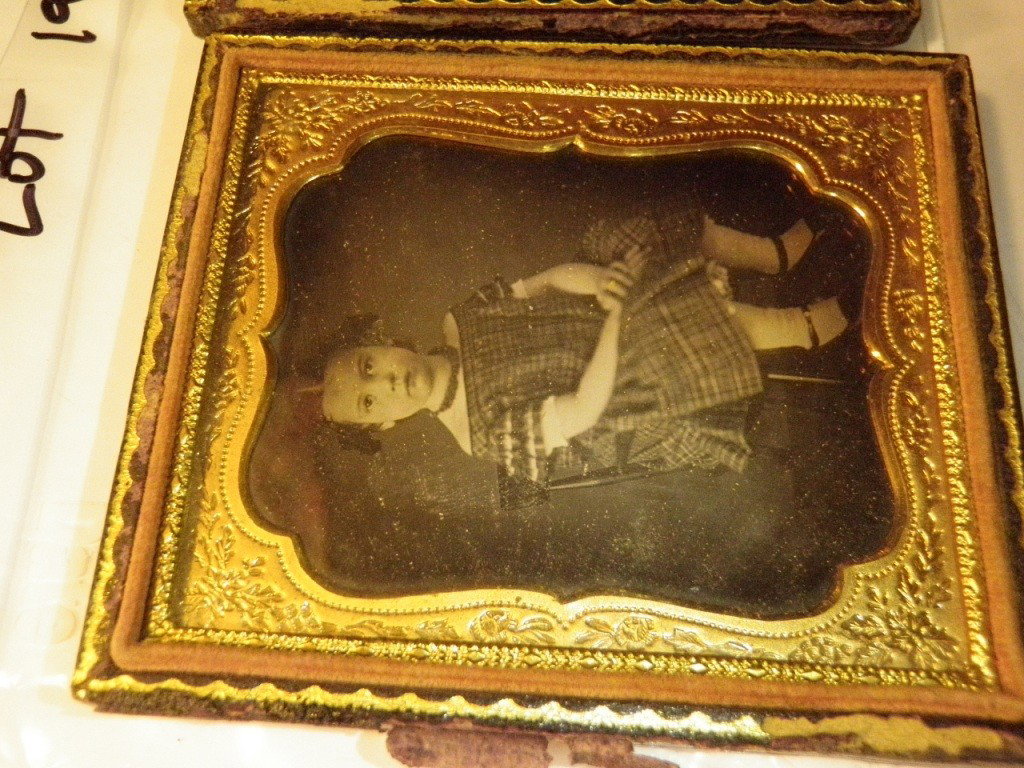 Daguerreotype: Shows a little girl sitting in a chair. Comes in a velvet lined frame, frame has some damage. Measures 3 x 3 1/2".
