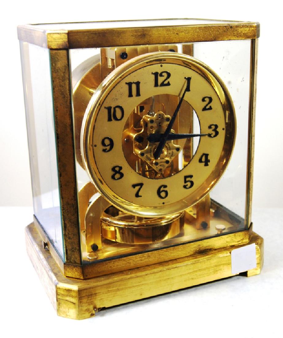 Jaeger Le-Coultre "Atmos II" atmospheric clock, Swiss: Jaeger Le-Coultre "Atmos II" atmospheric clock, Swiss made, black Arabic numerals on a brass dial marked "Atmos by Jaeger LeCoultre", case with glass sides and top, 15 Jewel Swiss movement, with seria