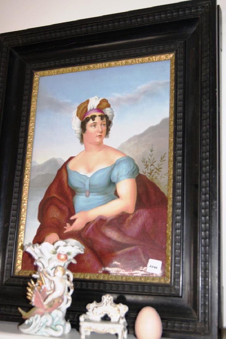 Large painting on porcelain wall plaque depicting lady: Large painting on porcelain wall plaque depicting lady in blue dress with red robe and turban white and red hat, in deep ebony frame with gilt liner, 20"x26" frame size, 13"x19" sight