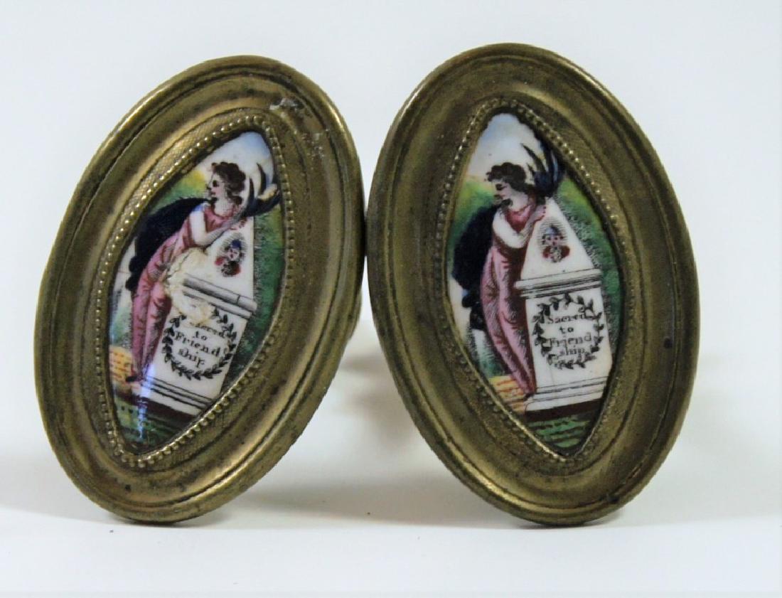 Pair of Antique Battersea "Memorial" enamels framed in: Pair of Antique Battersea enamels framed in a pair of oval brass screw in tie backs, with an angel next to a monument and slogan "Sacred to Friendship", oval is about 2" ht
