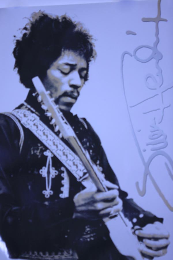 MUSIC POSTER: MUSIC POSTER **|**|** 24X36 INCHES; UNFRAMED; This poster shows Jimi Hendrix from the side as he plays his guitar. On the right is a copy of his signature. Jimi Hendrix was a guitarist, songwriter, an