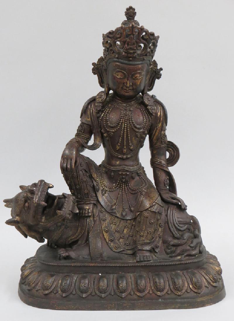 BUDDHIST GILT-LACQUER BRONZE FIGURE OF GUANYIN: heavily-cast Bodhisattva Avalokiteshvara of the Lion's Roar (Shi Hou Guanyin) with elaborate crown and ornamentation, seated in the Royal Pose of Relaxation upon a lion, and perched on a lotus base, 2