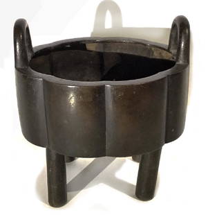 SMALL CHINESE BRONZE RITUAL VESSEL (DING): Qing, lobed octagonal-form, two loot handles, four cylindrical legs, undecorated, 5"h; 4.5"diam.Partial old paper label attached to base, The British Antique Dealer's Association....