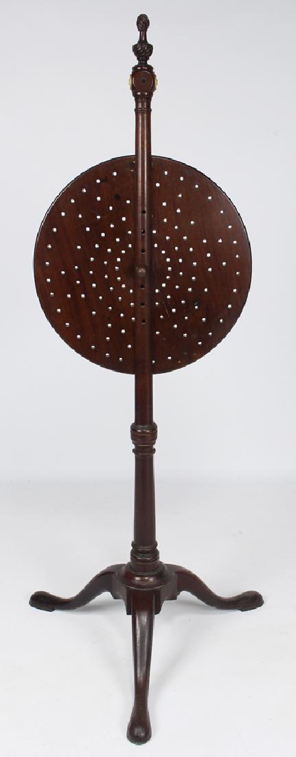 UNUSUAL ENGLISH GEORGE II MAHOGANY FIRE SCREEN: the height of the pierced rotating round screen adjusts with peg, the pole with turned bone rosette at the top is mounted on Queen Anne snake foot base, 48.5"h; 16"diam. The round screen rot