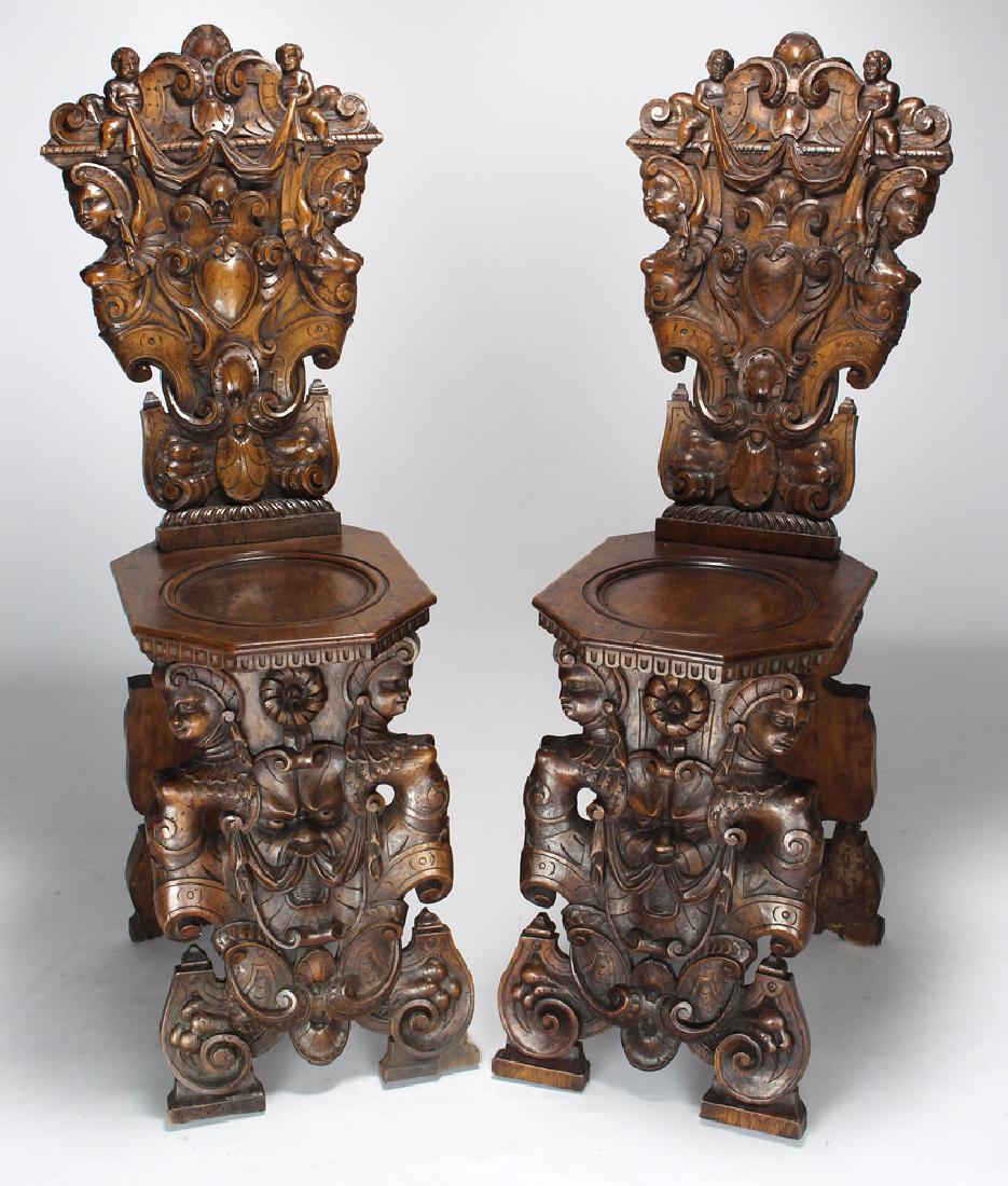 PAIR OF ITALIAN CARVED WALNUT HALL CHAIRS (SGABELLO): 19th c., carved figural backs and front seat supports, 44"h; 12.75"w