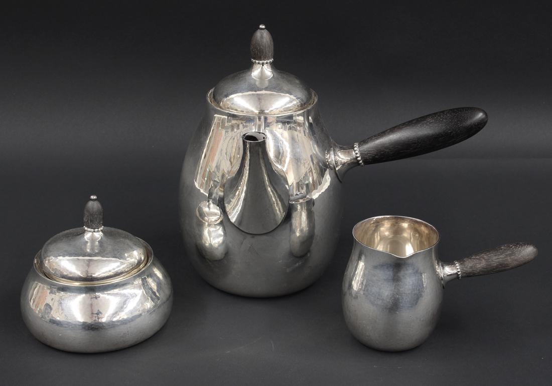 3-PIECE GEORG JENSEN STERLING SILVER TEA SET: marked, C10/DENMARK/GEORG JENSEN/STERLING/80C consisting of a teapot, 7.5"h; a creamer, 3"h; and a covered sugar, 4"h; all with ebony