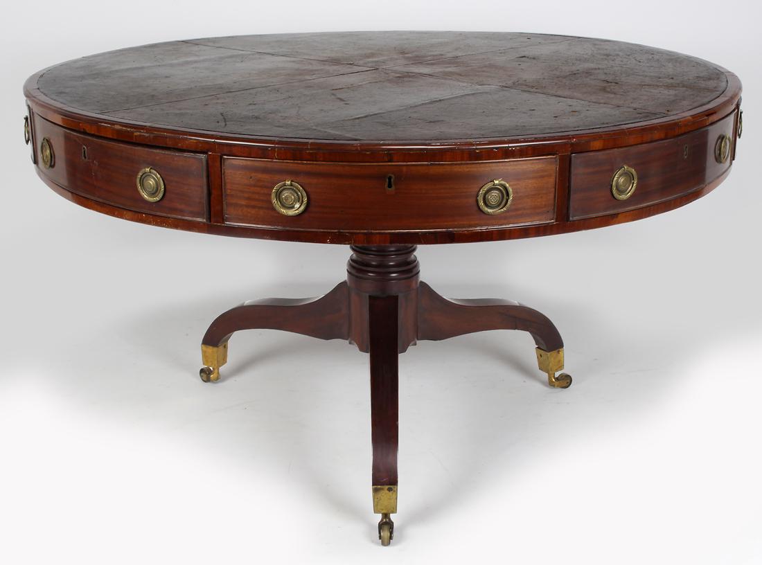 LARGE REGENCY MAHOGANY DRUM TABLE: inset brown leather, rotating top, eight working drawers, turned pedestal base with triffid feet, on brass casters, 29.5"h; 52"diam. Retailer's label: Osborn T. East, 166 Great Po