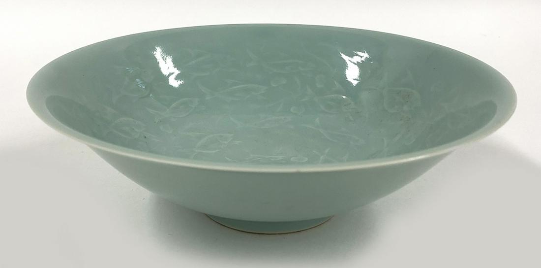 KOREAN CELADON PORCELAIN BOWL: 19th c., prob. earlier, faint illegible mark in oval on bottom thin and delicate, flared footed-form, the interior filled with raised design of fish swimming among aquatic foliage, 2.75"h; 8.5&qu