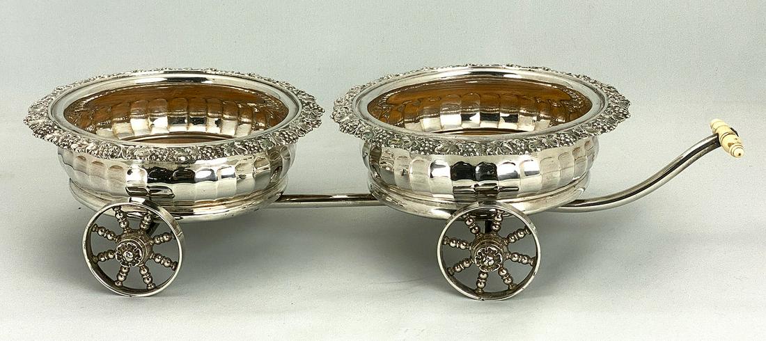 T & J CRESWICK, SHEFFIELD WINE TROLLEY: 19th c., hallmarked with crossed arrows, reticulated baskets have turned wooden coasters, scrolled grape decoration, turned bone handle and spoked wheels; 16"