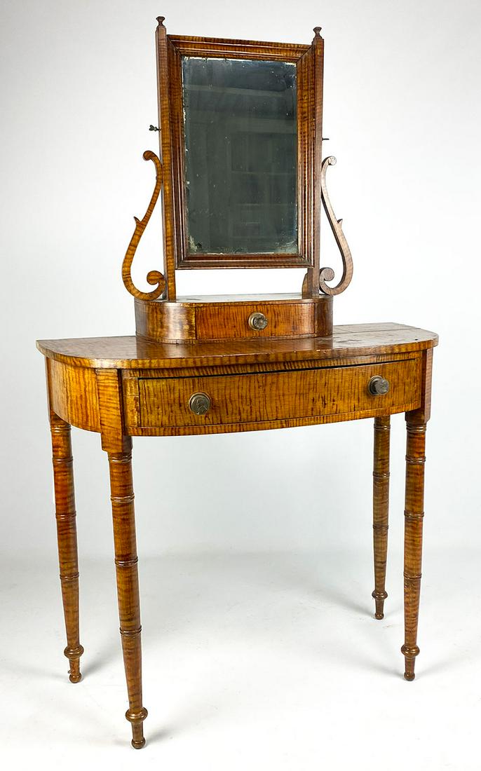 NEW YORK SHERATON FAUX-PAINTED TIGER MAPLE DRESSING: bow-front table c. 1840, mirrored top section with drawer, lower part with bowed apron drawer with embossed brass George Washington knobs, 70"h; 36"w; 17.5"d From an historic Massachuse