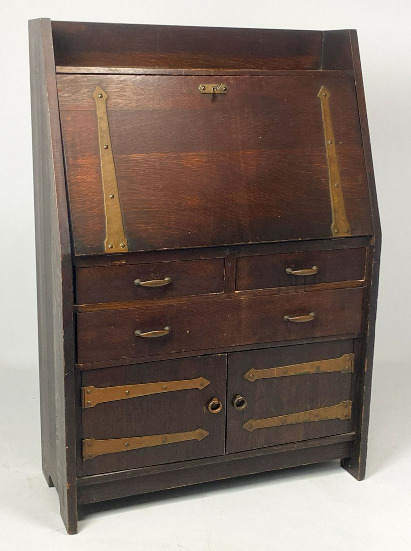 GUSTAV STICKLEY OAK FALL-FRONT DESK: red mark on reverse, dense quartered stained oak, two drawers over one over pair of cupboard doors, original copper hinges and hardware; fitted with compartments, 48"h; 33"w; 14"d