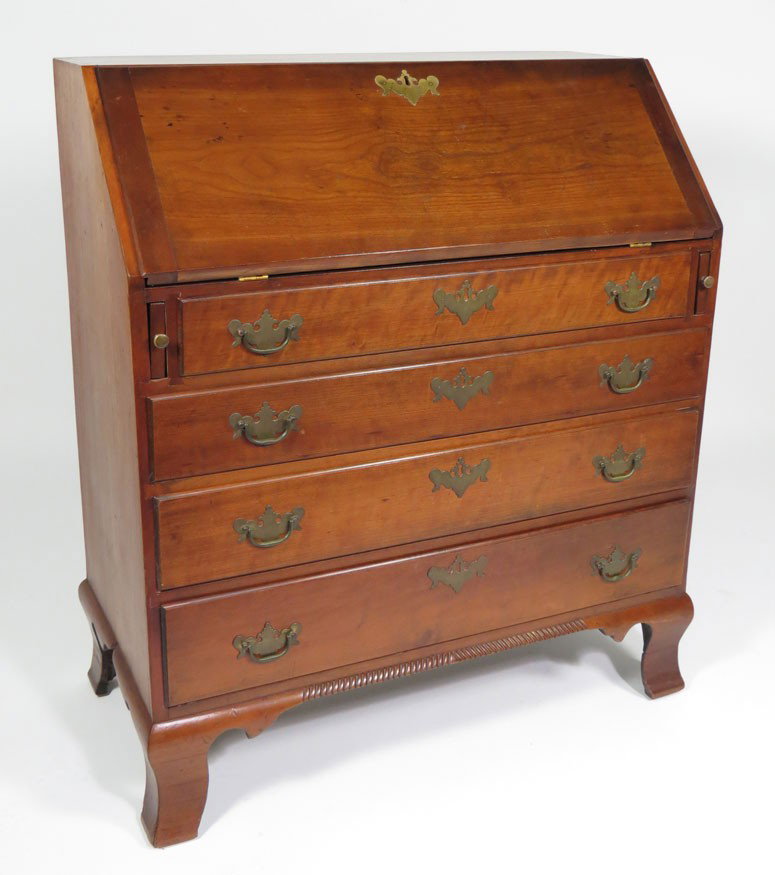 CONNECTICUT CHIPPENDALE CHERRY SLANT-LID DESK: c. 1785, simple fitted interior of drawers and cubby holes, four graduated drawers, with gadroon carved apron and ogee feet, 42”h; 36”w; 17.5”d
