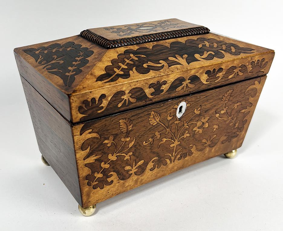WILLIAM IV FLORAL INLAID DOUBLE TEA CADDY: sarcophagus-form, with ornate floral and leaf inlay on top and front panel; mother-of-pearl escutcheon and top oval plate; interior with 2 lidded compartments with line inlay; 5.5"h; 9"w; 5.