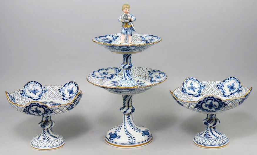 (3) PIECE MEISSEN PORCELAIN SWEETMEAT SET: c. 1870, blue floral decoration with reticulated border, crossed sword mark consisting of a two-tiered center piece with figural top, 16”h; and a pair of compotes, 6.5”h; 9” diam.