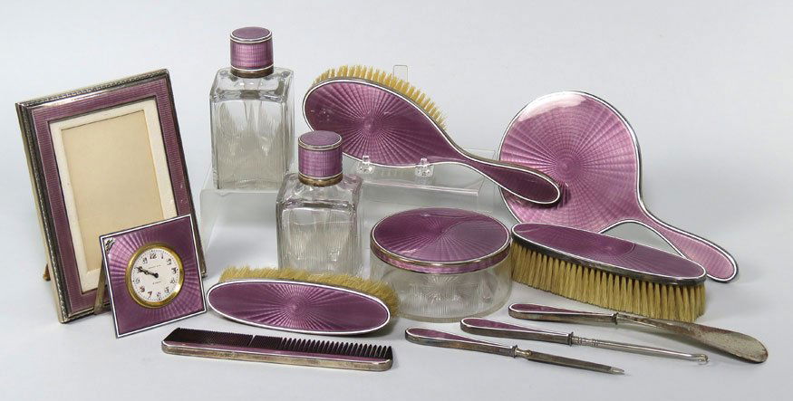 (on 13) TIFFANY STERLING AND ENAMEL DRESSER SET: Tiffany & Co., pale purple enamel decorated consisting of a hand mirror; a picture frame, 5 by 7”; (2) perfume bottles, 5”h; (3) various brushes; round covered jar; small clock (damaged); comb; na