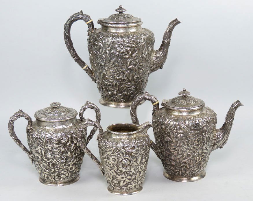 STERLING SILVER 4-PIECE TEA AND COFFEE SERVICE: J. E. Caldwell & Co., 19th c. overall floral repousse design, consisting of a coffee pot, 8.5”; a teapot; a covered sugar and a creamer, 85 total troy oz. Monogram on bottom HLE who received set as