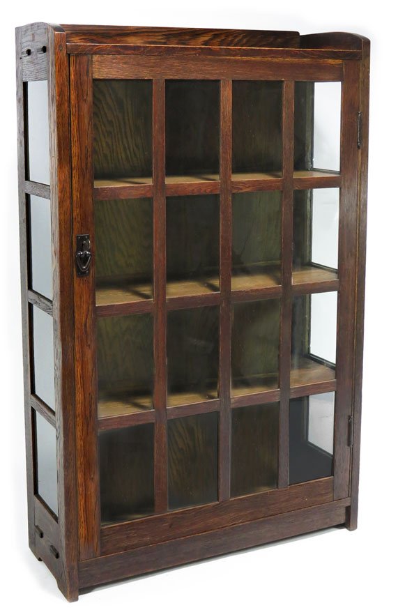 GUSTAV STICKLEY ARTS AND CRAFTS OAK BOOKCASE: c. 1908, No. 715, original surface paper label on reverse and firm’s red joiner’s compass decal inside, gallery top over glazed door with sixteen panes of glass V-pull, exposed tenons on side pane