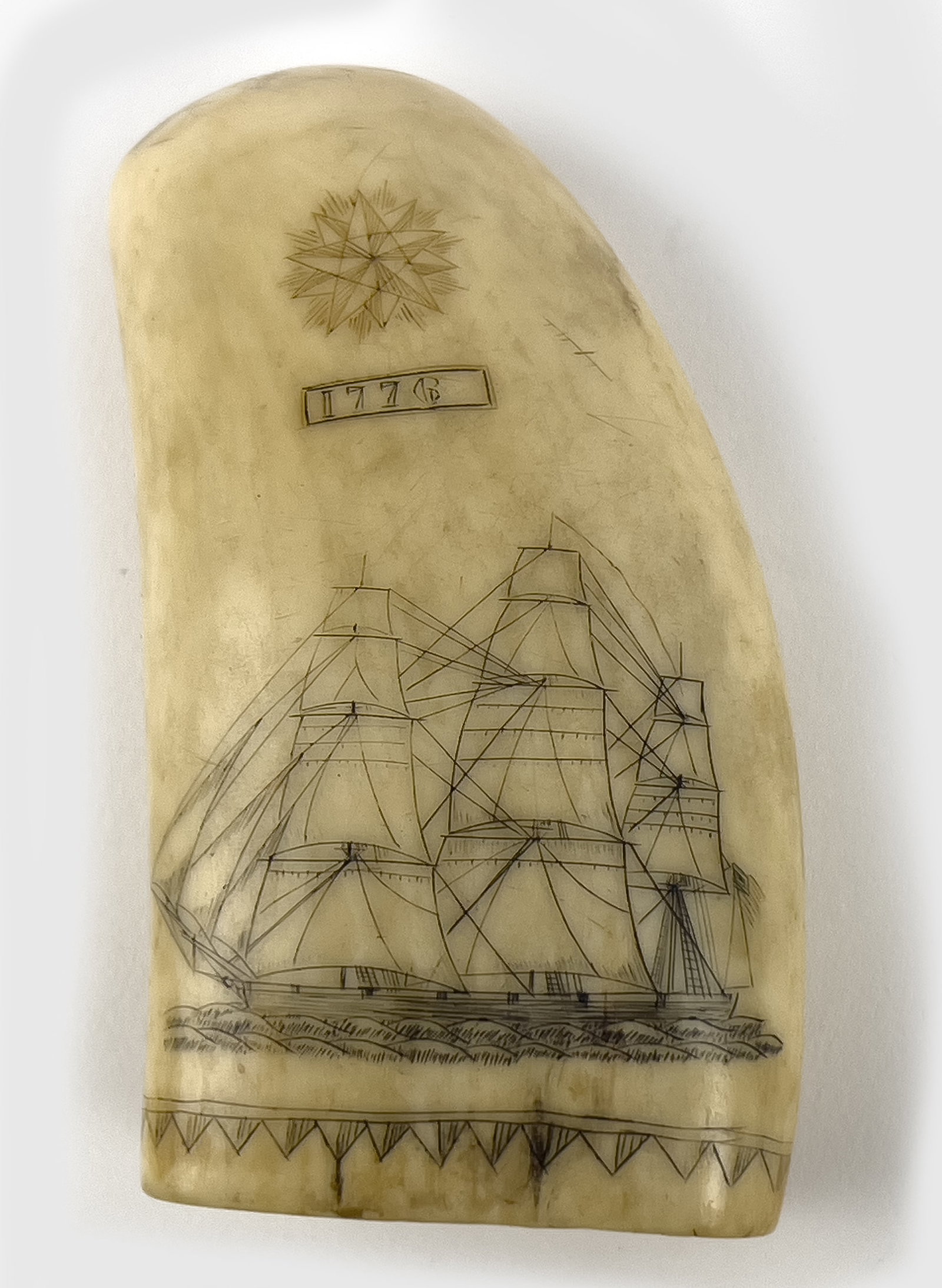 19TH C. SCRIMSHAW WHALE TOOTH, LIBERTY: decorated with full-masted ship; above, a compass rose and dated 1776; the reverse with American emblem with eagle LIBERTY; the base circled with sawtooth band; 4.5"; 2.5