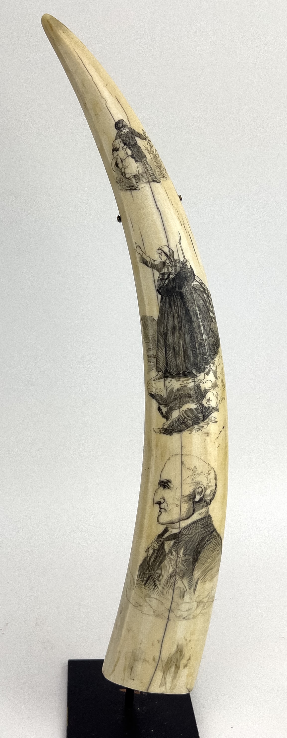 19TH C. SCRIMSHAW WALRUS TUSK: 19th c., decorated with a profile portrait of a gentleman wearing a medal; in the middle, a stout woman wearing a plaid shawl; and above, a young brother and sister; the reverse undecorated; 16.5"; on