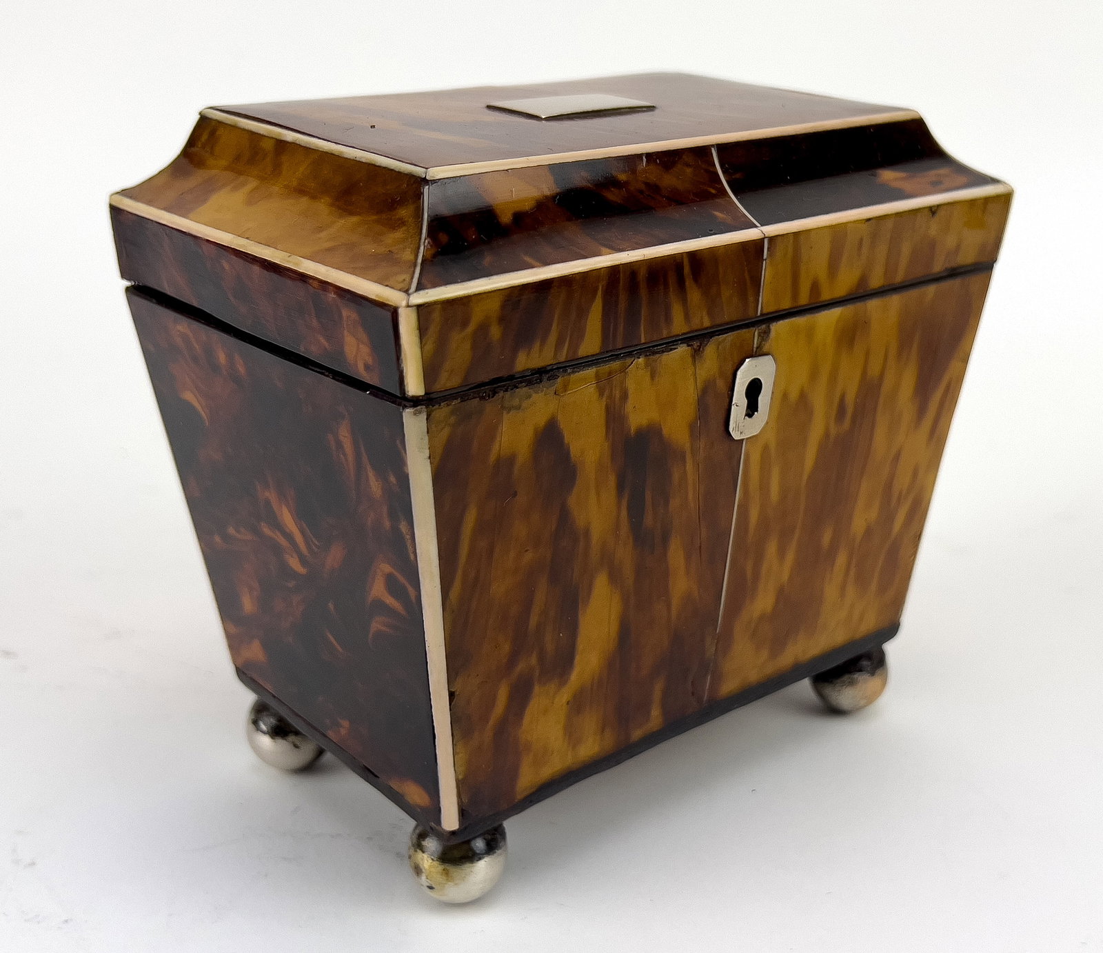 ENGLISH GEORGIAN TORTOISE SHELL TEA CADDY: tapering rectangular-for; double fitted interior with shell lids; silver escutcheon and blank lid plaque; metal ball feet; 5''h; 5.25''w; 3.5''d NOTE: Apologies, we cannot approve bidders during the a