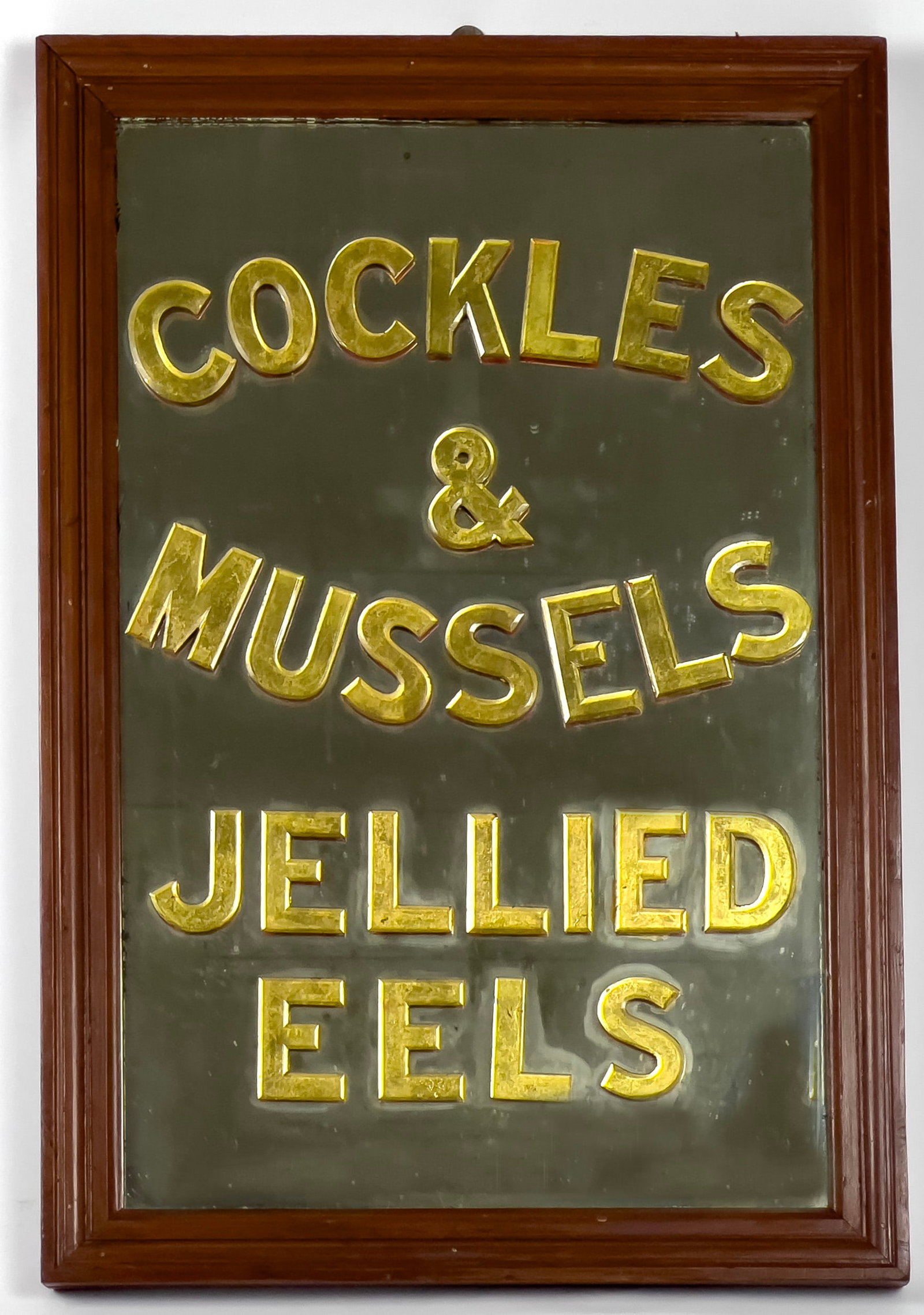 ENGLISH PUB WALL MIRROR: applied beveled, acrylic letters COCKLES & MUSSELS / JELLIED EELS, wood frame; 31" by 21" NOTE: Apologies, we cannot approve bidders during the auction.