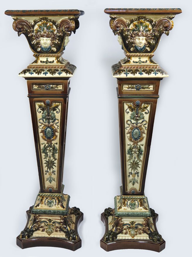 PAIR OF ORNATE SWEDISH MAJOLICA PEDESTALS, RORFTRA: marked MADE IN SWEDEN: Rorftrand decorated in brown, gold, blue and green glazed female masques, stylized flora and fauna, the in-curving base adorned with claw feet, 45”h; 13”w; 13”d
