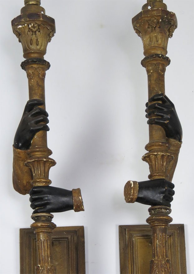 PAIR OF ITALIAN TORCH-FORM WALL BRACKETS: each with a cuffed blackamoor hand holding a torch, converted to electricity, gilded plaster, rectangular wood and metal mount, 40”h