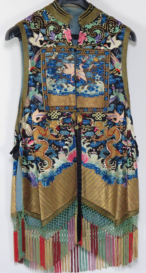 CHINESE EMBROIDERED SLEEVELESS VEST: 20th c., civilian stork banner to front and reverse finely embroidered dragons, storks and florals to front and back, 35” not including fringe, lined in blue silk