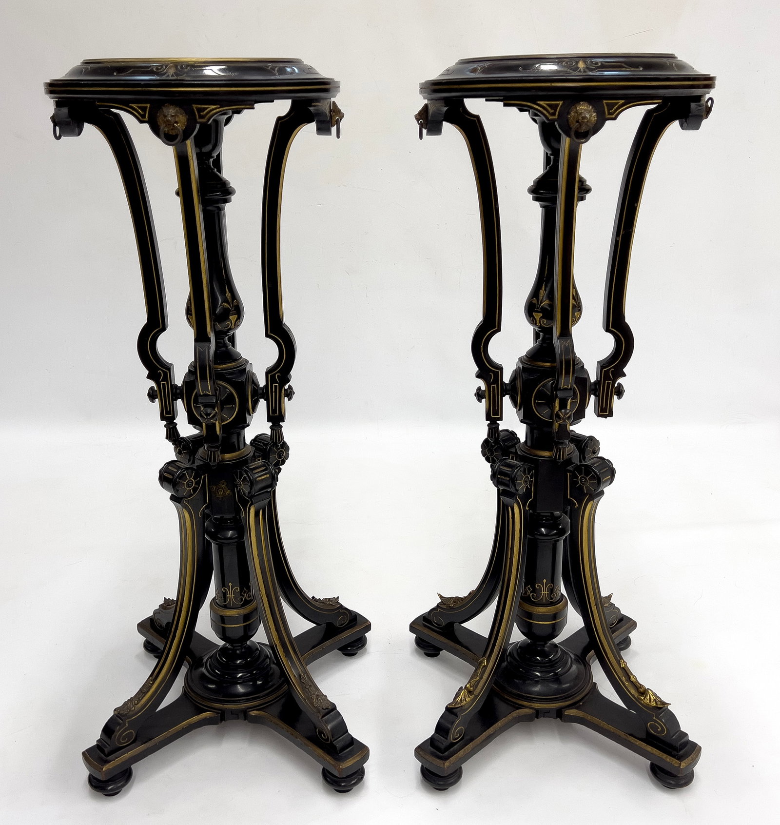 PAIR OF VICTORIAN AESTHETIC MOVEMENT PEDESTALS: ebonized with brass and gilt enhancements; 41"h; top 15"d, platform 11" diam.