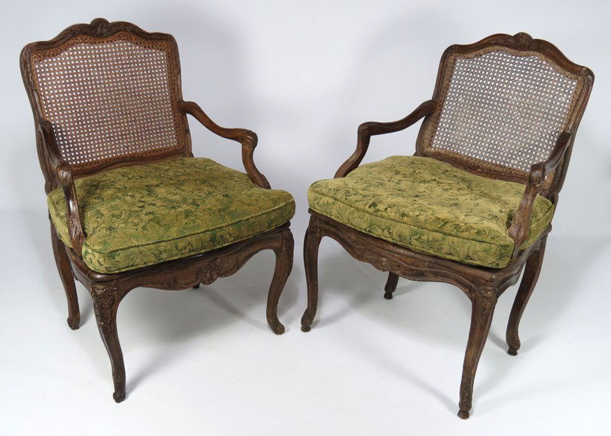 NEAR PAIR FRENCH LOUIS XV CARVED WALNUT FAUTEUILS: carving to crests, arms and cabriole legs, caned back and seat, with cushions, 36.5”h; 24.5”w
