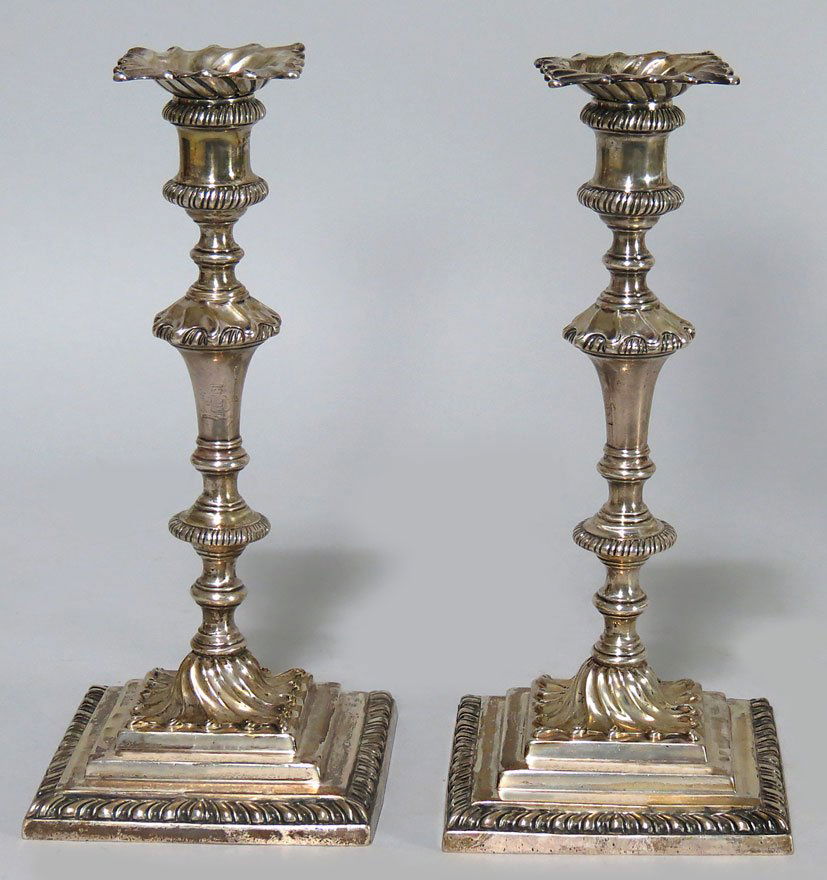 PAIR OF ENGLISH GEORGE II SILVER CANDLESTICKS: London, Daniel Smith and Robert Sharp, 1760 with swirled bobeches, turned and chaised column, swirl above square stepped base, with gadroon edge, hallmarked on base and bobeche, 10.25”h, 54 troy oz.